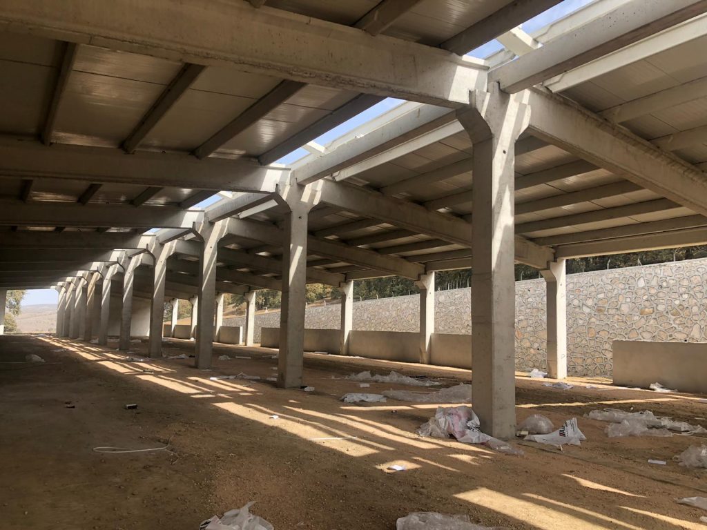 Prefabrik betonarme kolon ve çatı makaslarından oluşan açık yanlı yapının içeriden görünümü